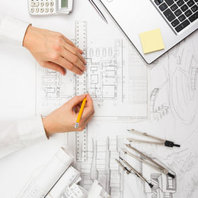 Architect working on blueprint. Architects workplace - architectural project, blueprints, ruler, calculator, laptop and divider compass. Construction concept. Engineering tools.